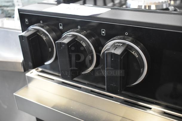 Black stove control panel with three knobs labeled "Off," "Lite," and "Hi." Stainless steel trim, good condition.