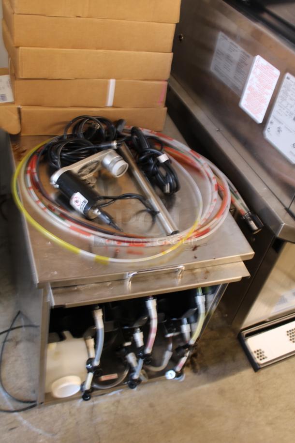 Commercial beverage dispensing machine with hoses, cables, and a motor. Appears in used condition, with visible connectors.