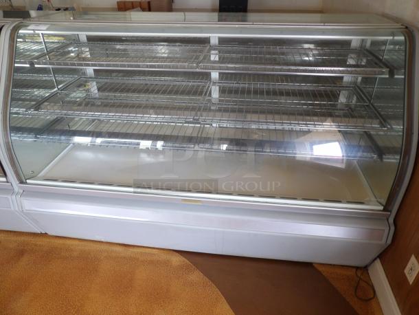 One Structural Concepts Curved Glass Refrigerated Bakery Display Case. 220 Volt. Curved Glass In Front, With 2 Rear Slide Doors, Lighted Donut Display Case, 4 Rack Powers on and works as should - Image 1 of 5