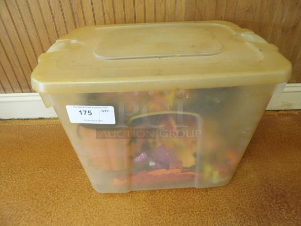 Plastic storage bin with lid, filled with assorted items. Auction tag "175," suggesting bulk content for PGIauctions.com.