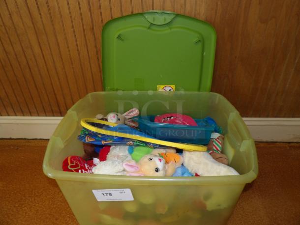 Green storage bin filled with assorted plush toys, hula hoops, and a blue container. Label reads "178 qty." Good condition.