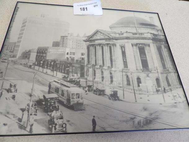 Framed vintage photograph of an early 20th-century urban scene featuring a historic domed building and streetcars. Auction tag 181.