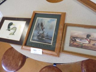 Three framed duck prints featuring mallards, each with distinct artwork styles; middle print matted in wood frame. Auction tag "183".