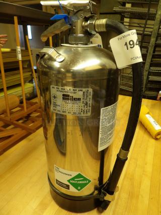 Stainless steel fire extinguisher, model Silco, hydro-tested, non-flammable rating. Auction tag 194 visible.