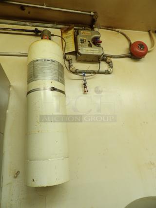 Kidde WHDR-400L fire suppression system, mounted. Visible wear, labels detail usage and maintenance.