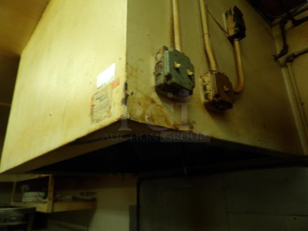 Industrial kitchen exhaust hood with electrical conduits. Visible wear and rust. Labels present but illegible.
