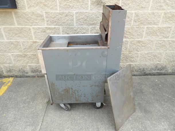 Vintage industrial metal cart on wheels, showing significant rust and wear. Features two compartments and an open side panel.