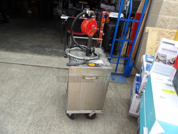 Mobile fuel pump unit on wheeled cart, features a red hand-crank pump, hose, and a metal tank. Used condition.