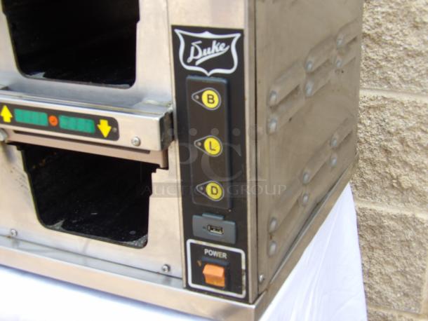 Duke warming drawer, stainless steel, visible control buttons, power switch, in good condition with exterior markings.