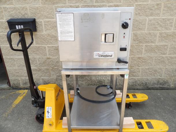 Cleveland steam oven on metal stand, power and reset dials, label shows operating instructions, sturdy condition.