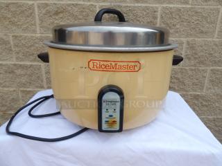 Vintage RiceMaster rice cooker, 55-cup capacity, with stainless steel lid. Visible wear on cream exterior. Power indicator light.
