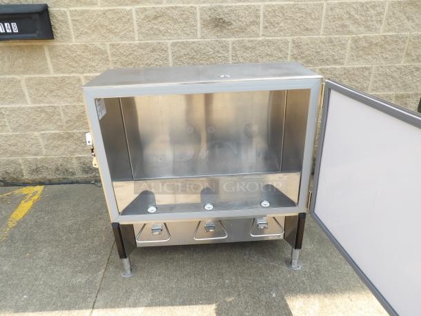 Stainless steel commercial warming cabinet with open door, adjustable legs, and three bottom compartments. Good condition.