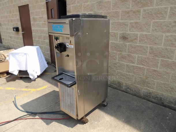 Electro Freeze soft serve machine, stainless steel, used condition, visible scuffs, label on top, suited for commercial use.
