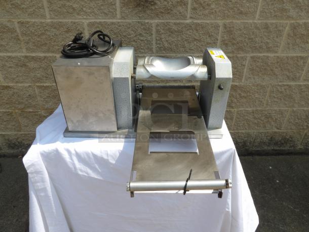 Industrial dough sheeter machine, stainless steel, electric, good condition, visible power cord, mounted on white cloth.