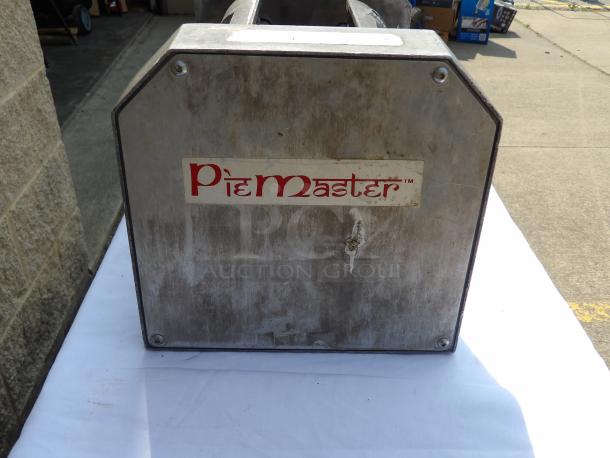 Vintage PieMaster machine, metal exterior with visible wear, features brand label. Ideal for collectors or restoration.