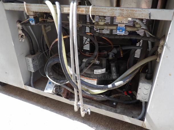 Industrial HVAC unit components, showing refrigerant lines, compressor marked with model 8904762, in worn condition.
