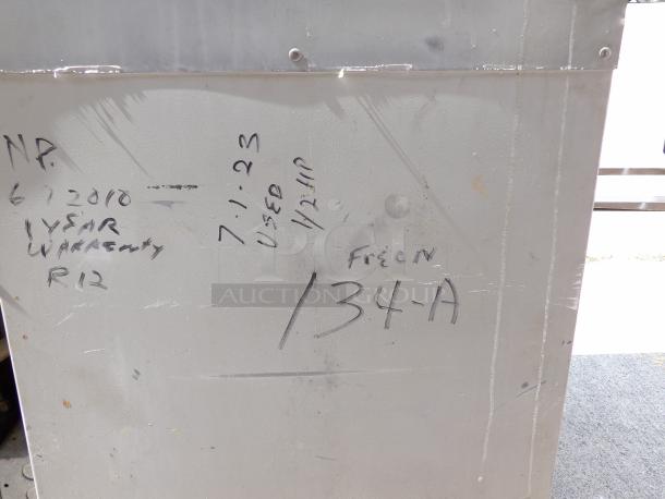 Industrial metal container with handwritten notes: "6/2010, 1-year warranty, R12" and "7/1/23, used 1/2 HP, Freon 134-A." Used condition.