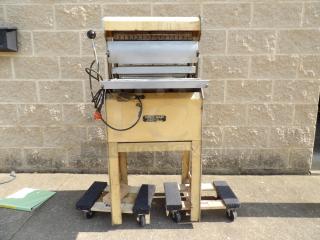 Vintage Safety-Slicer machine on wheels, with a metal slicer mechanism. Appears used, with a yellow body and lever.