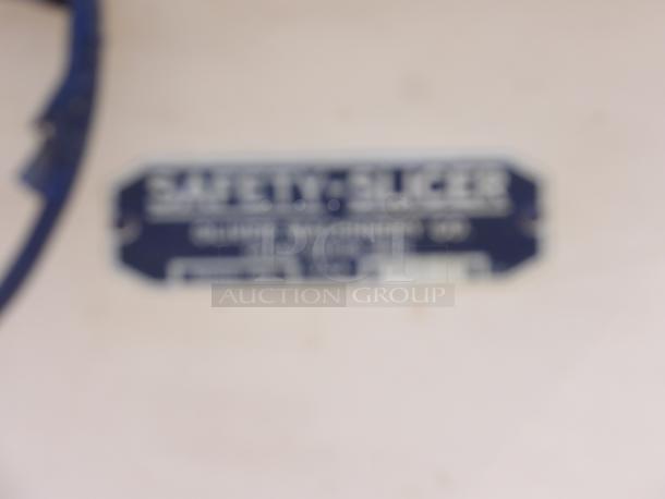 Blurred label reading "Safety Slicer," with illegible manufacturer details, on a blue-framed background.