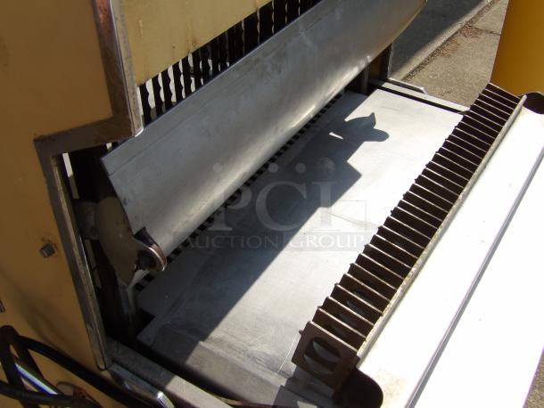 Industrial metal guillotine with sharp blades, used for cutting. Visible in used condition with some rust on parts.