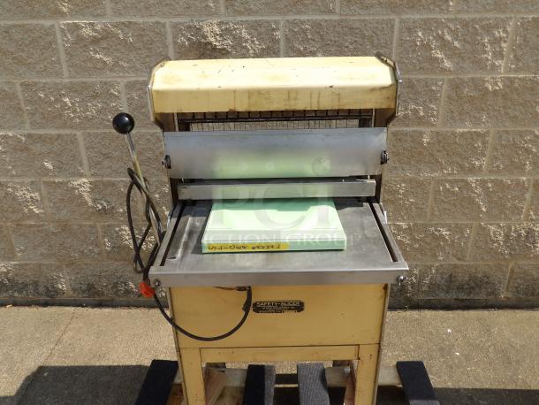 Antique metal paper cutter, labeled "Safety Slicer," with manual lever. Visible wear. Includes green cutting mat.