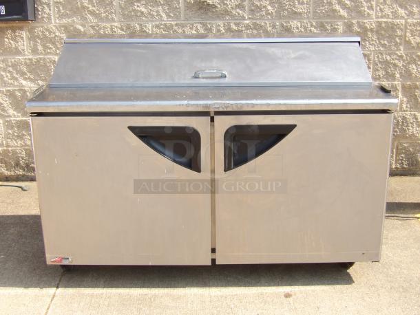 Commercial stainless steel sandwich prep table with a hinged lid and dual doors. Good condition with minor wear.