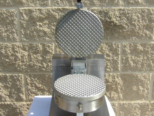 Stainless steel commercial waffle maker with open plates, textured surface, and sturdy build, in good condition.