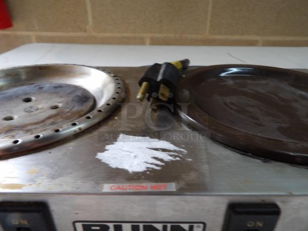 Bunn coffee warmer with dual hot plates, showing signs of use and wear. "Caution Hot" label visible. Plug included.