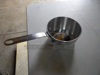 Stainless steel saucepan with long handle, new condition, circular base label showing usage instructions.