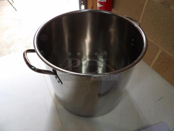 Stainless steel stock pot with two handles, showing light wear. No visible brands or labels. Suitable for large-scale cooking.