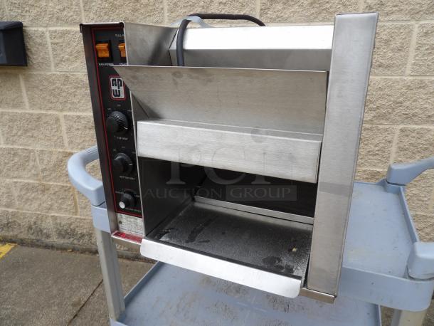 Commercial conveyor toaster by APW Wyott, stainless steel, adjustable heat controls, used, on cart.