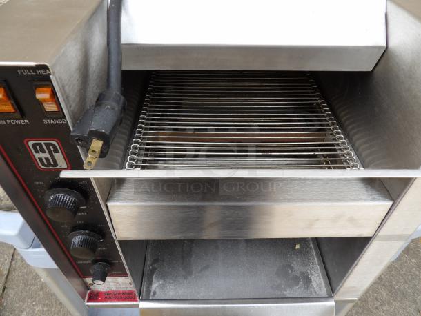Stainless steel conveyor toaster with adjustable heat settings, visible controls, and power cord. Good condition.