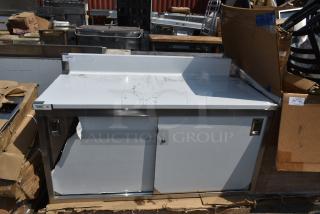 BRAND NEW SCRATCH AND DENT! Regency 600EBTB3060D Regency 30" x 60" 16 Gauge Type 304 Stainless Steel Enclosed Base Sliding Door Table with Adjustable Midshelf and 6" Backsplash.
