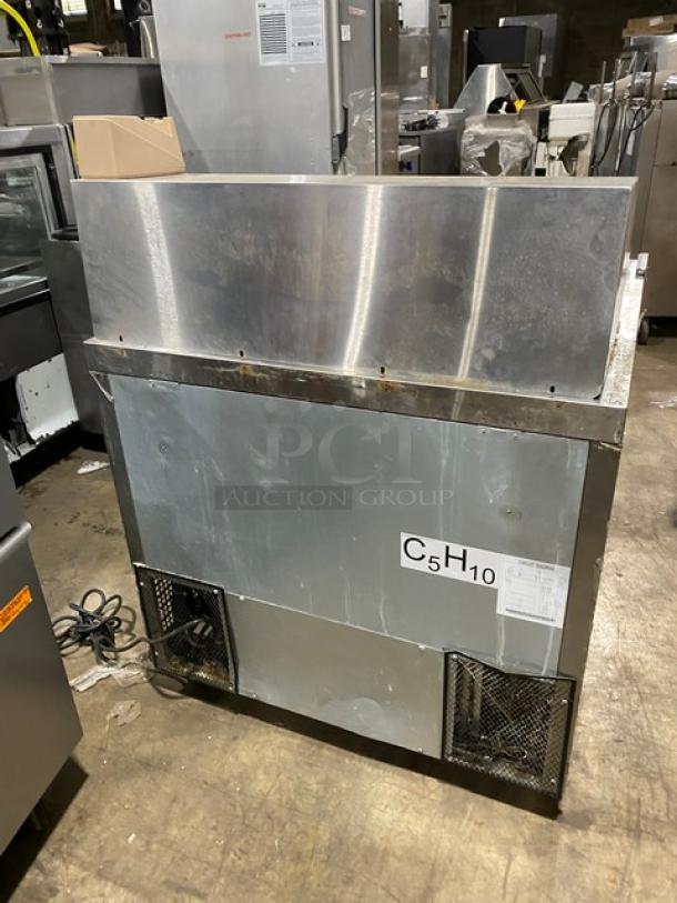Commercial stainless steel ice machine, model C5H10. Used condition with visible wear. Back view showing vents and power cord.