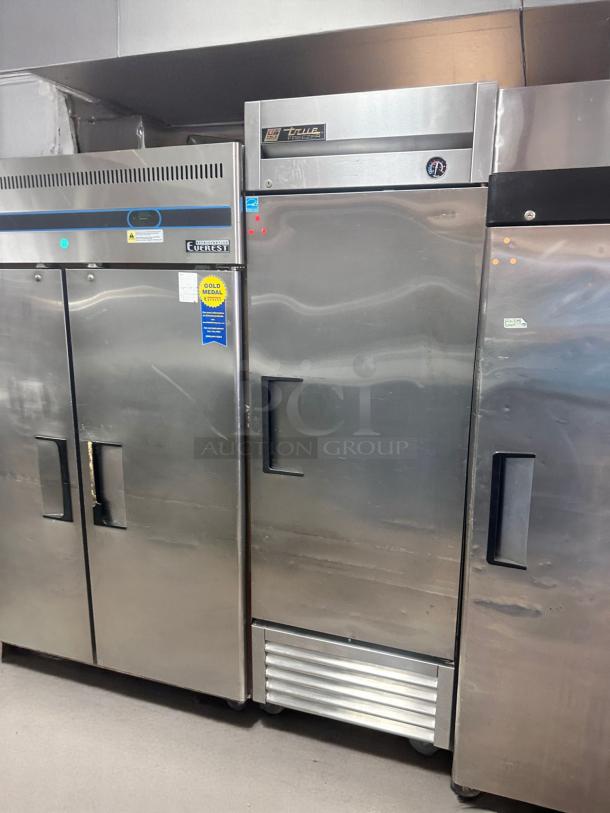 True industrial freezer, stainless steel, model T-49F. Visible temperature gauge. Used condition, minor surface wear.