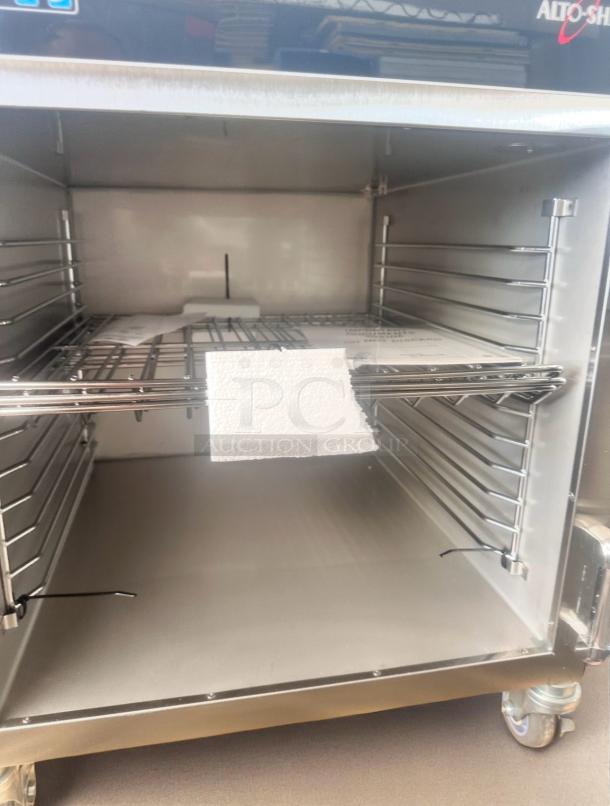 Commercial oven interior with multiple shelves, stainless steel finish, and attached insulation panel. Appears in new condition.