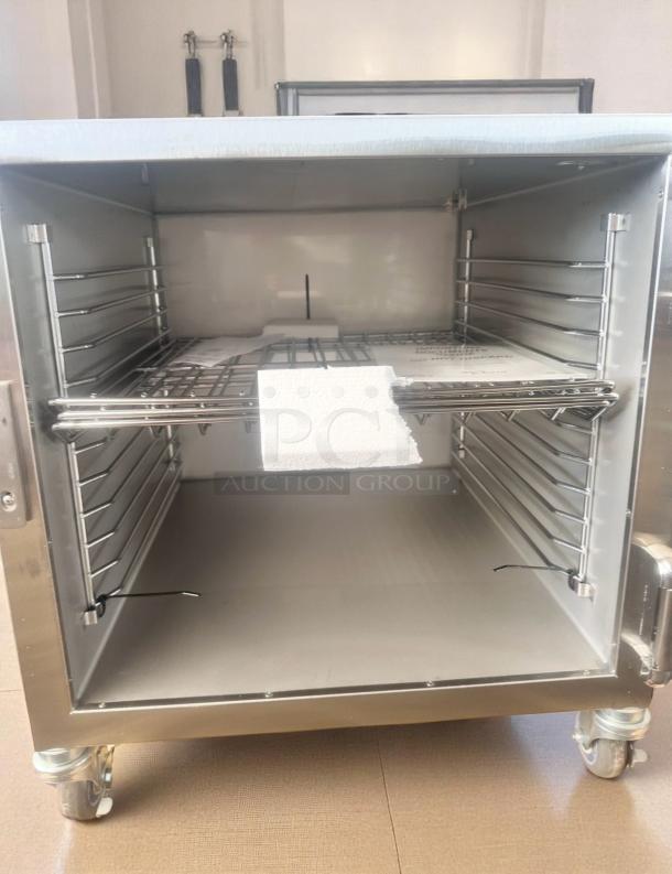 Stainless steel commercial warming cabinet, new, on wheels, adjustable shelves, interior label with instructions, pristine condition.