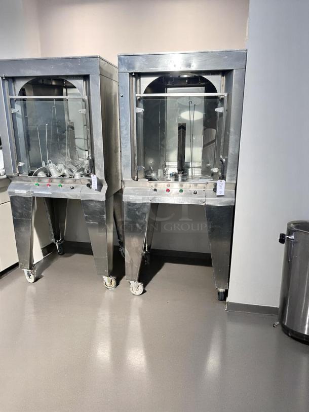 Two stainless steel Shawarma machines with glass panes, each on wheels. Visible control panels and labels. Excellent condition.