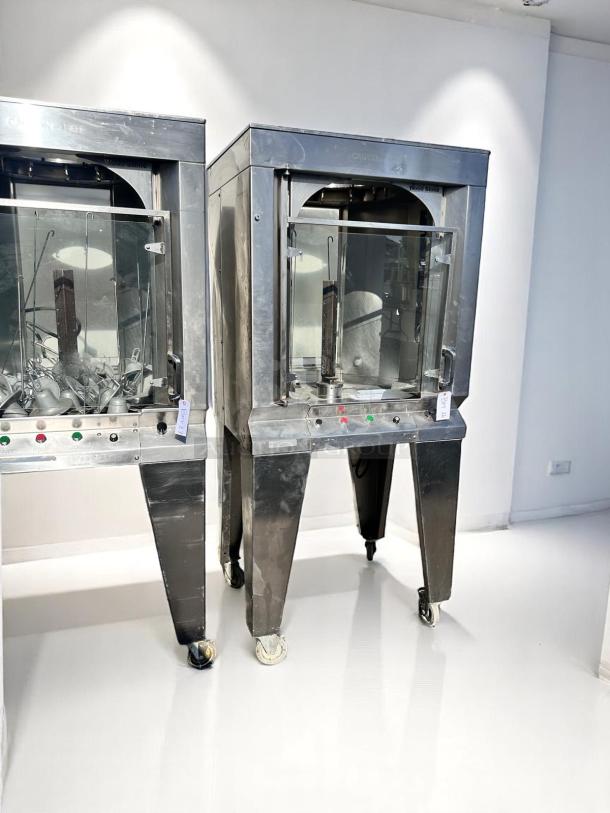 Two stainless steel commercial ovens with glass doors and control panels on wheels, displaying minimal wear.