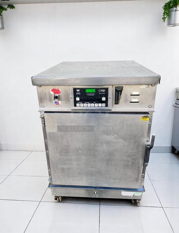Commercial food warming cabinet with digital controls, stainless steel, visible wear, CVap COOK & HOLD OVEN model, on casters.