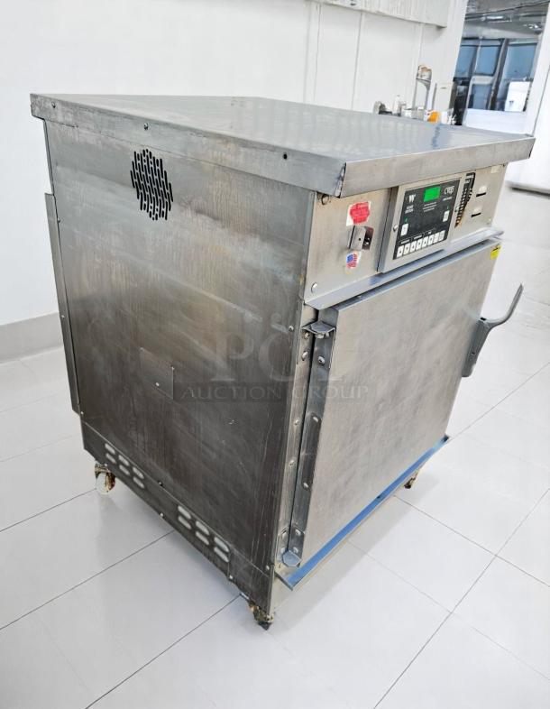 Industrial stainless steel oven on wheels, featuring control panel with labels, vent on side, good condition for auction.