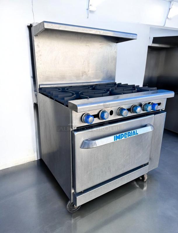 Stainless steel Imperial commercial range with six burners, oven, and blue control knobs. Excellent condition.