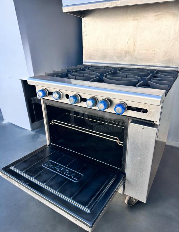 Commercial stainless steel stove with six burners, blue knobs, and "Imperial" logo on oven door. Excellent condition.