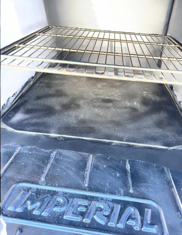 Interior of vintage Imperial oven, showing metal rack and base with "IMPERIAL" embossed. Condition shows signs of wear.
