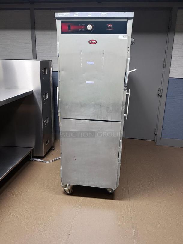 Silver commercial food warmer with wheels, red digital controls, FWE brand, used condition with minor wear.