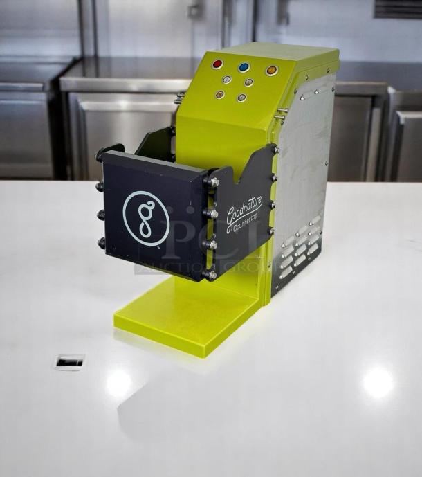Goodnature countertop juicer, lime green, good condition, logo on side, control buttons on top, sleek design.