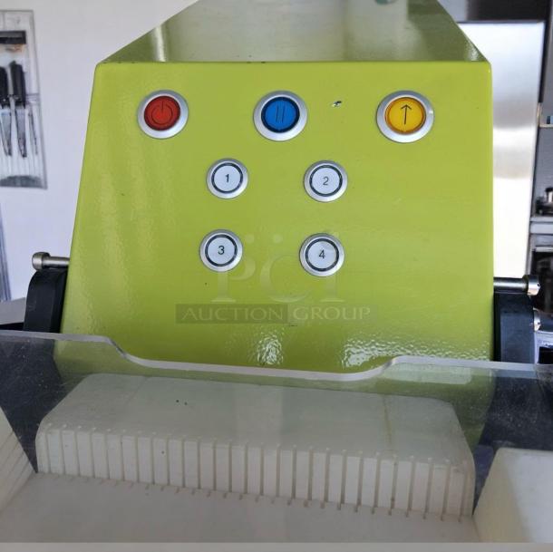 Commercial bread slicer with green control panel, featuring six buttons labeled for power and settings. Used condition.