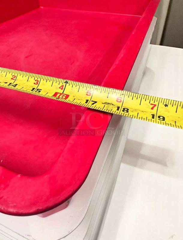Red plastic tray with a rounded edge, approximately 16 inches wide. Good condition, visible measurement tape indicating size.