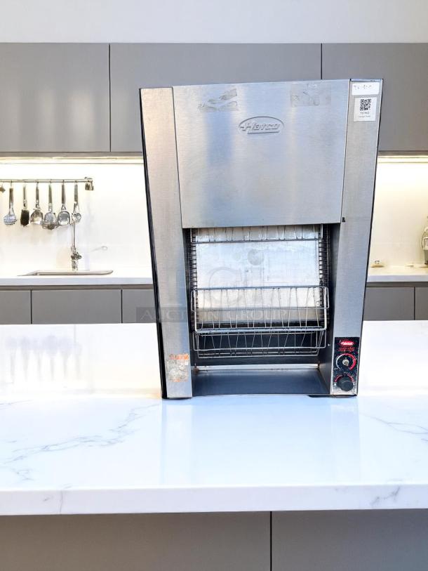Hatco commercial toaster, stainless steel, used condition, front controls, logo visible, placed on kitchen counter.