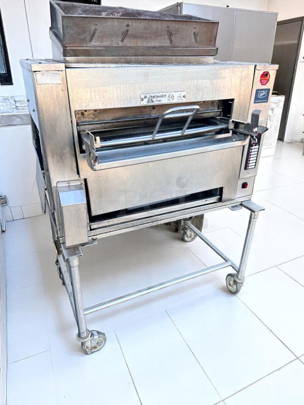 Commercial stainless steel pizza oven on casters, single door, digital controls, visible warning labels, good condition.